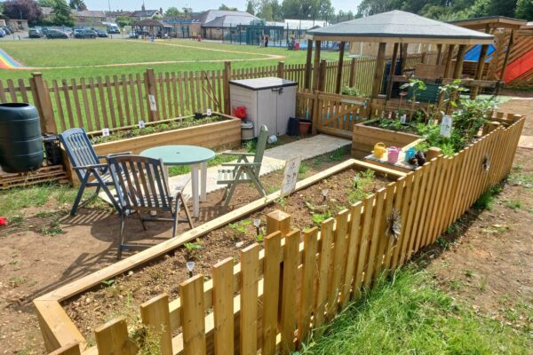 Fenced garden area with planters.