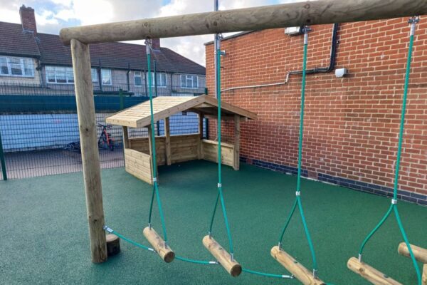 Log traverse and play lodge on a green surfacing